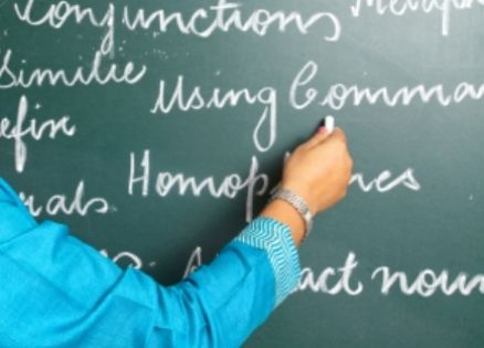 English teacher writing on chalk board.