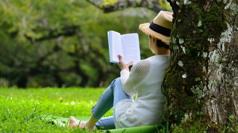 woman sitting against a tree in springtime