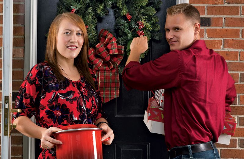 Jessica Distin with husband Blake at a front door with a wreath hanging on it