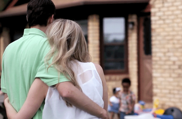 Man and woman embracing as they watch children play.