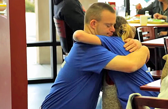 Tim embraces a customer for hug-a-thon.