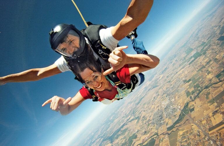 Marci Seither gives the high sign during her tandem jump with her instructer.