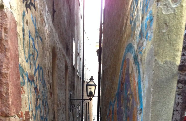 A narrow Stockholm alleyway lit up during an early-summer evening