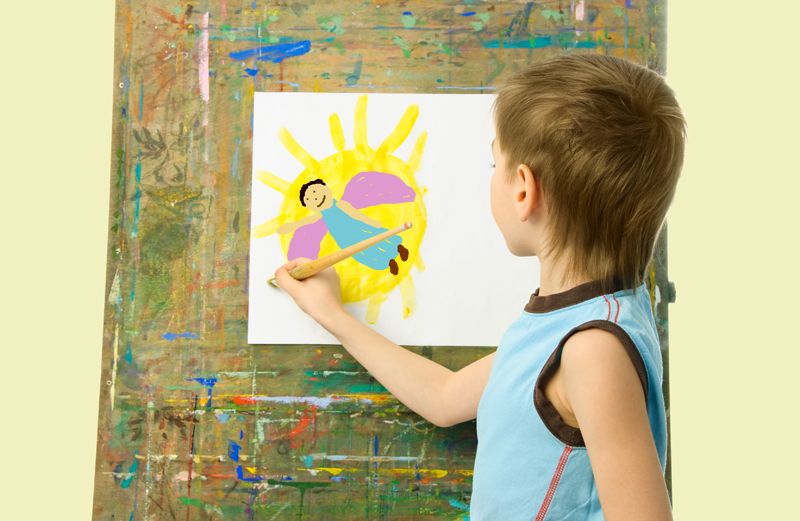 A boy paints at an easel.