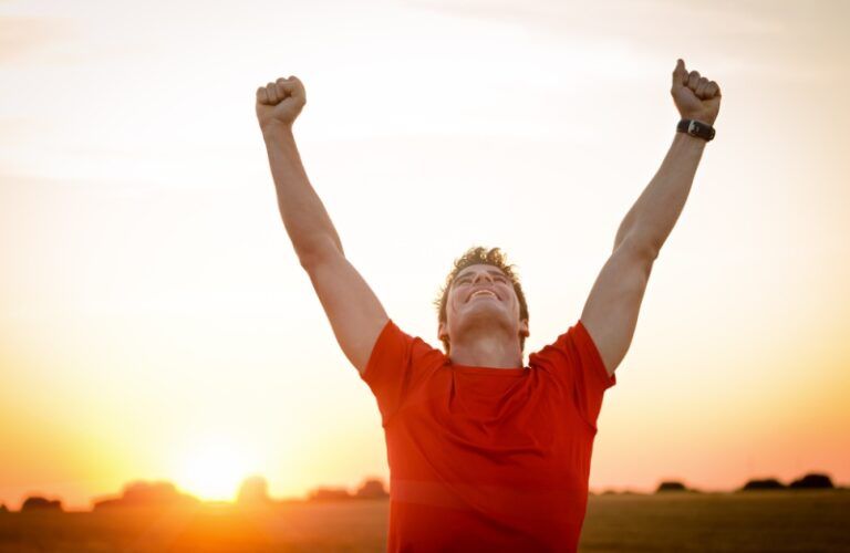 Man with arms lifted in triumph