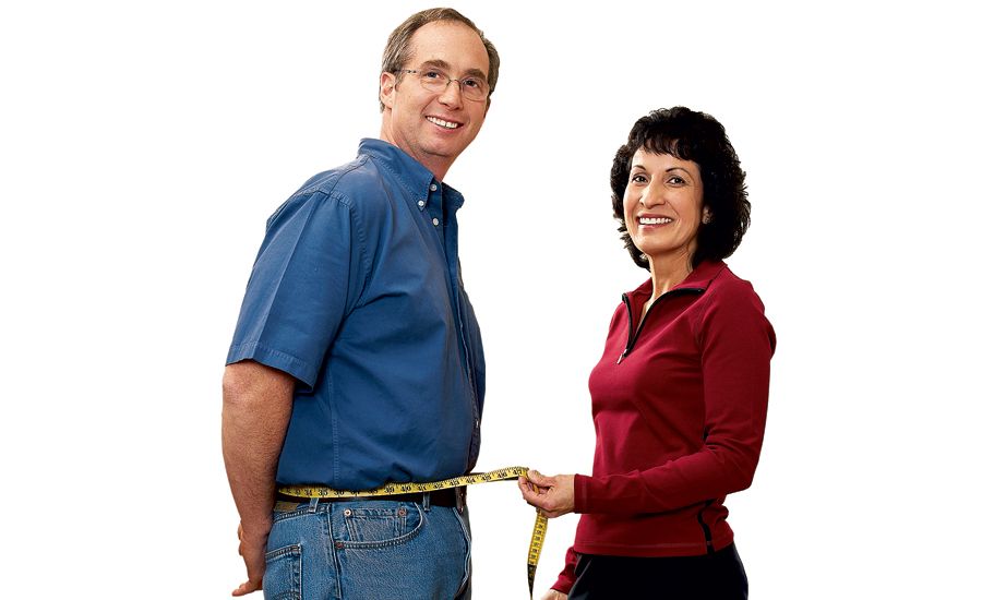 Mary wraps a tape measure around Tom's newly slim waist.