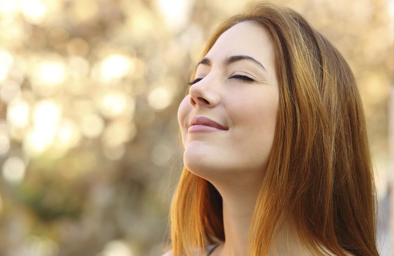 A woman practices mindfulness outside on an autumn afternoon.