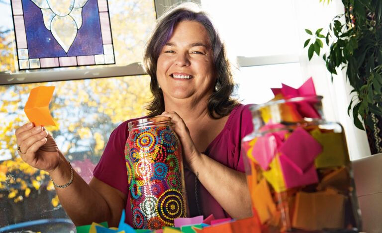 Sherry holds up one of the brightly colored notes from her smile jar.