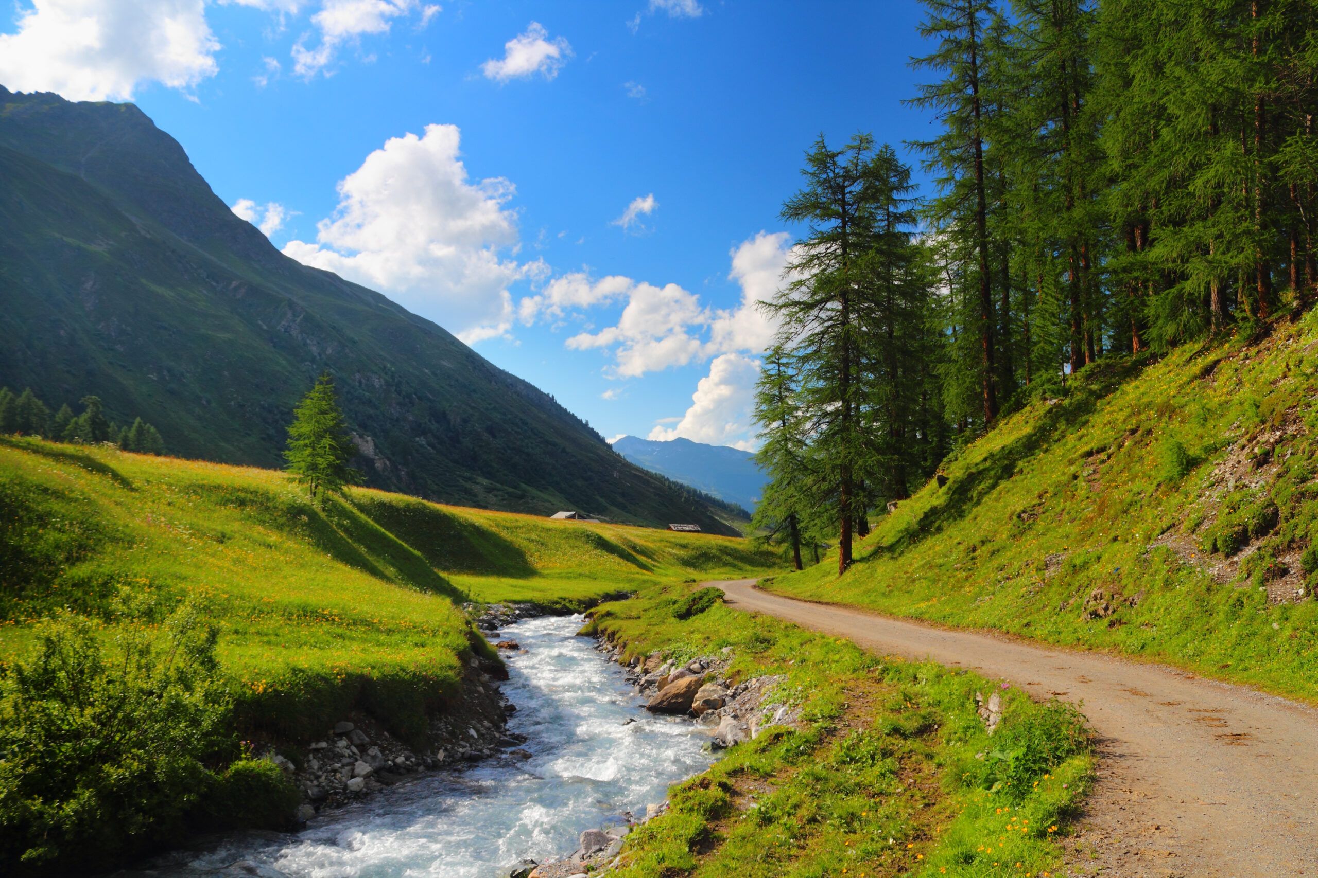 A path next to a stream through the mountains