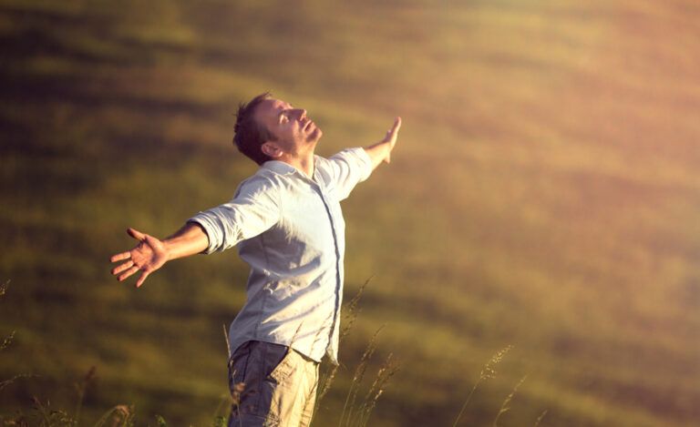 a man looks up to heaven with arms outstretched asking why God