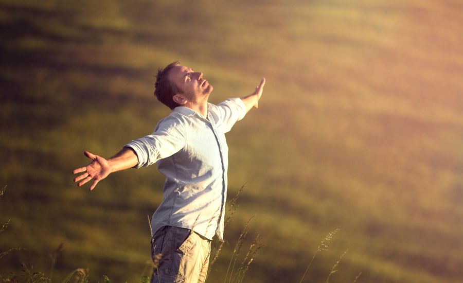 a man stretches his arms wide to feel the breeze