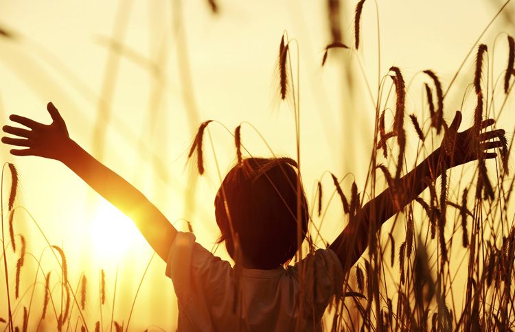 Child reaching into the sunset with a new year bible verse