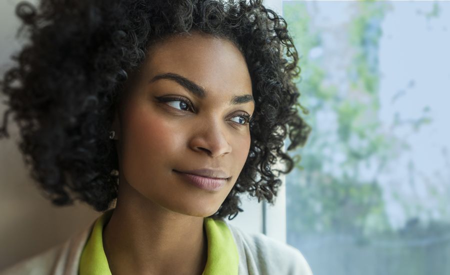 Guideposts: A woman gazes thoughtful out a window.