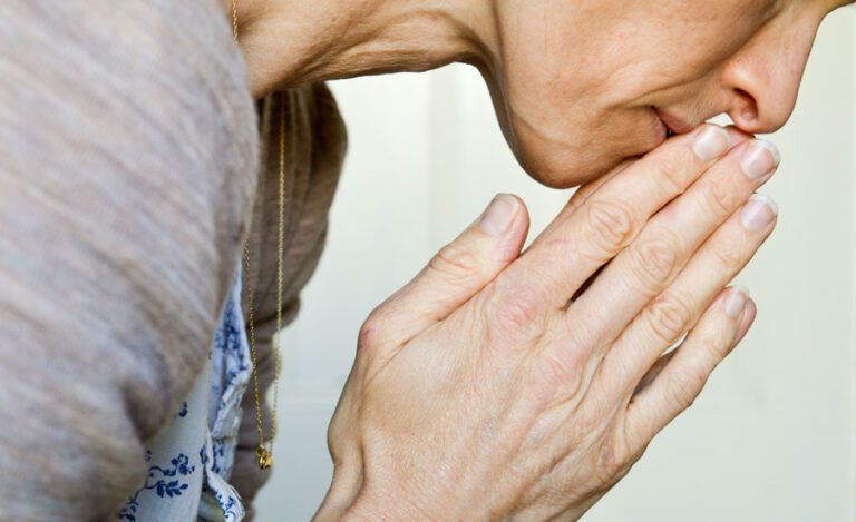 A mature woman prays for her godchild