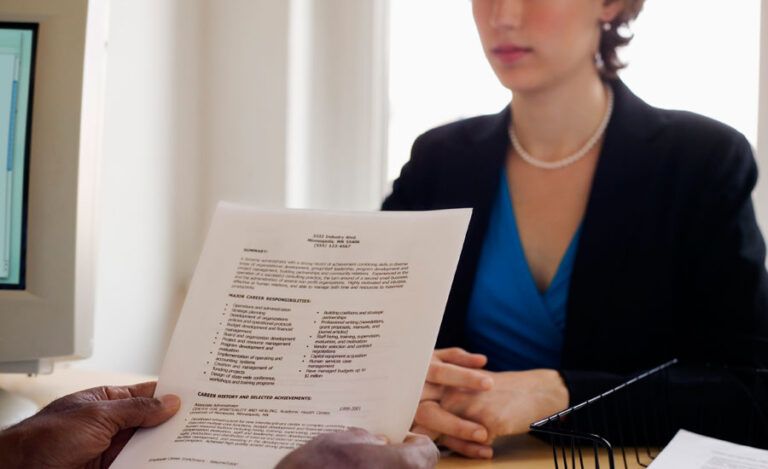 A woman sits with a human resources employee during a job interview