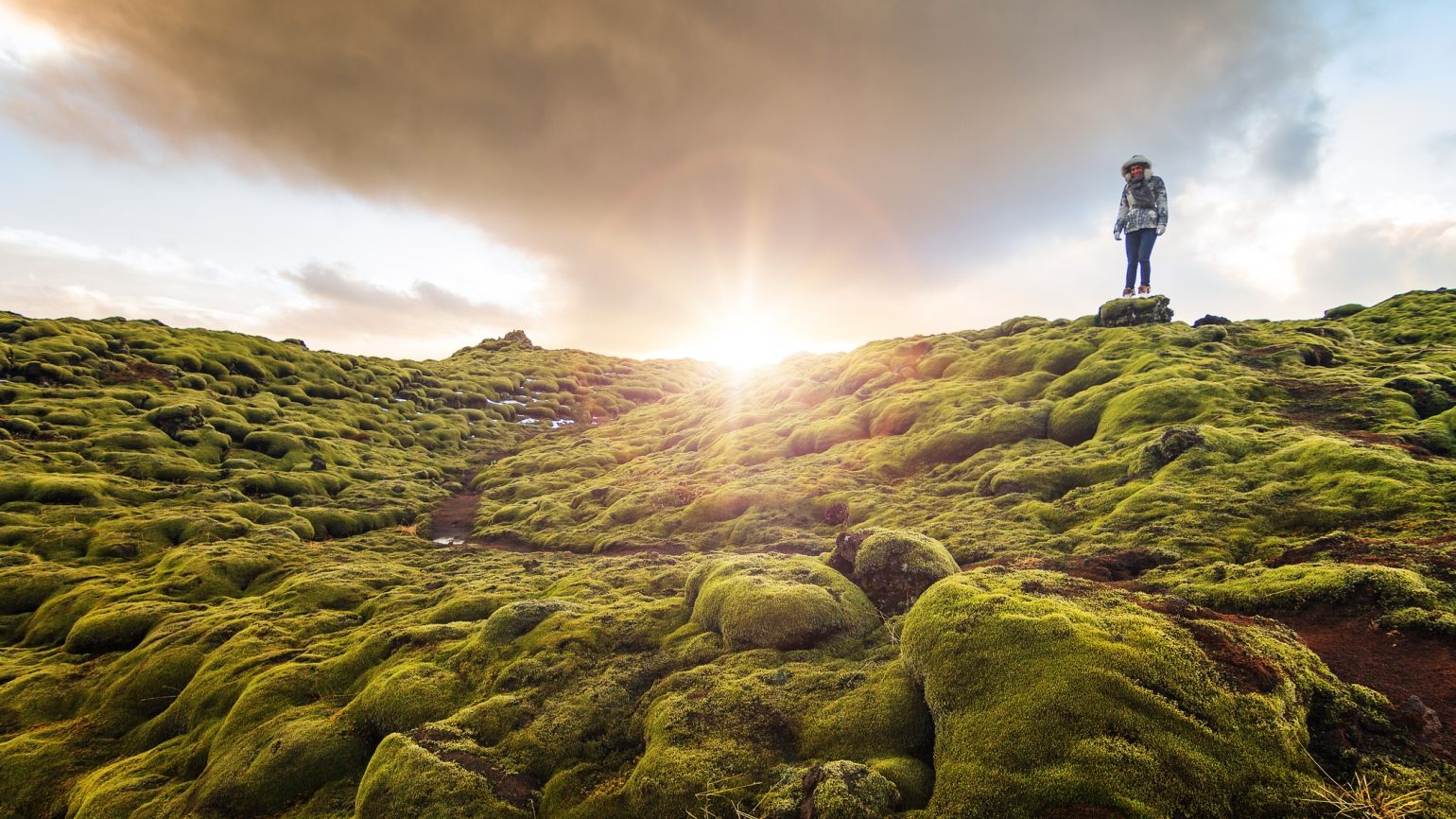 A person walking through the countryside at sunset with a new year prayer for safe travel