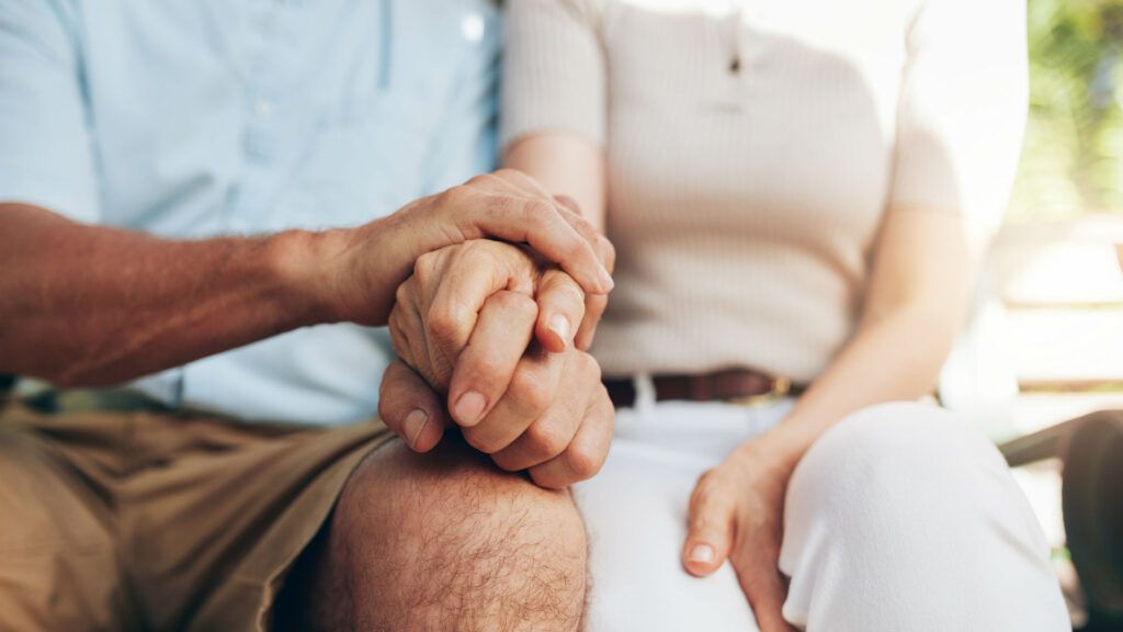 Elderly couple holding hands