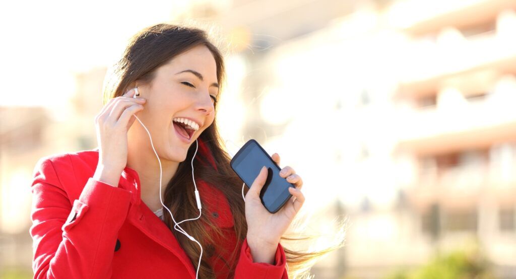 Woman listening and singing to music; Getty Images