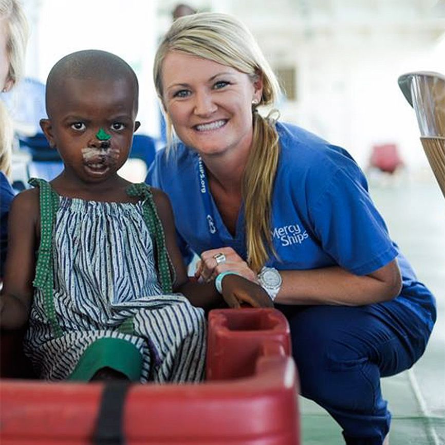 Heather poses with a young patient after her surgery