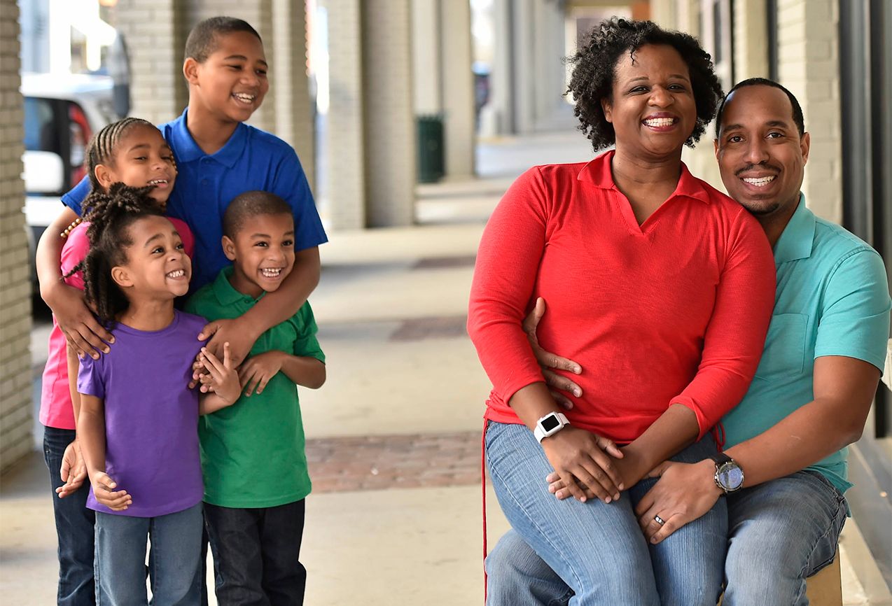 Danita and Paul pose for the camera, while their kids look on