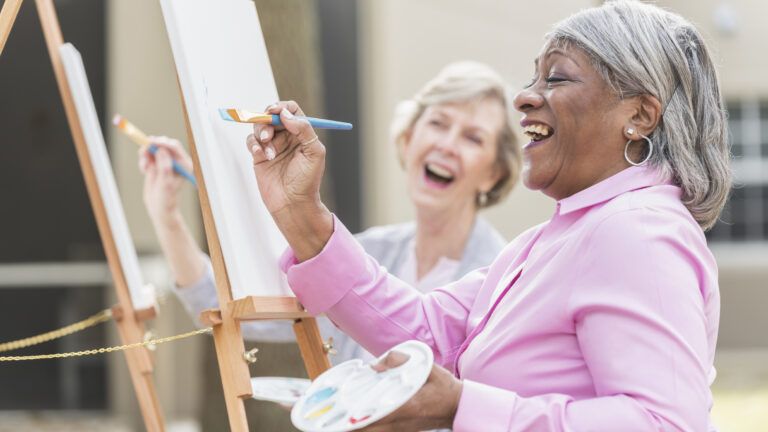 two senior women painting