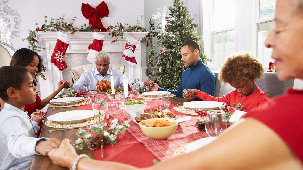 A family joins hands in prayer at Christmas