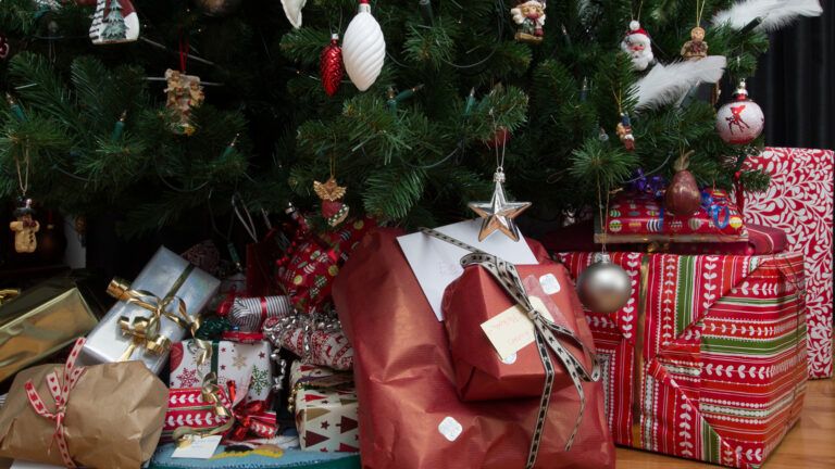 Colorful Christmas gifts underneath a Christmas tree.