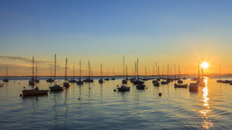 A brilliant sunset on a harbor full of ships.