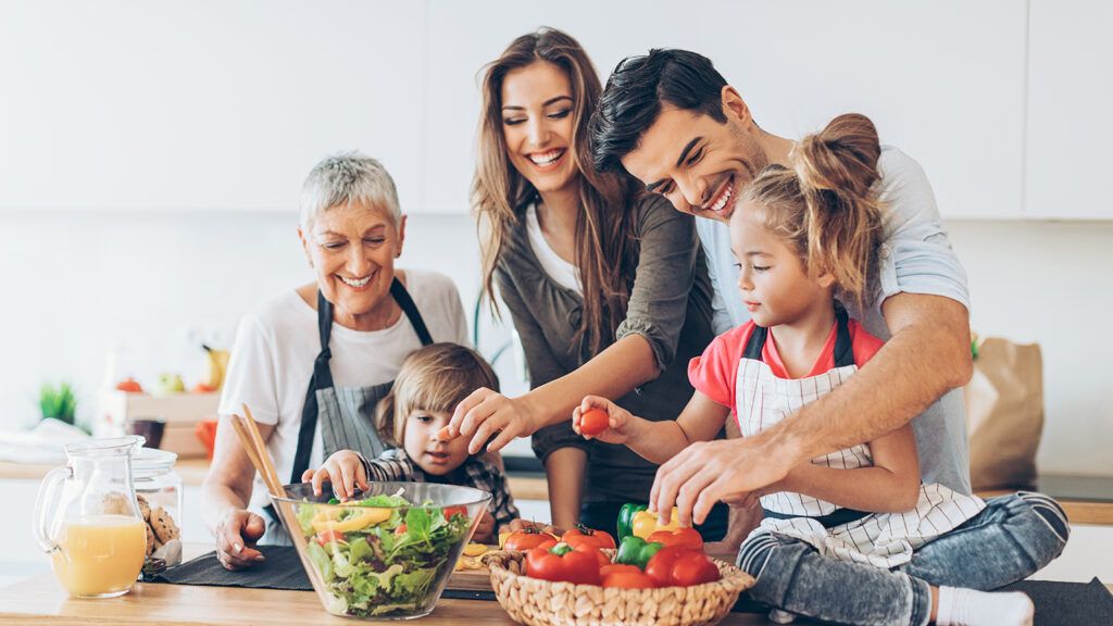 A happy group of people gathered in the kitchen for friends and family stories