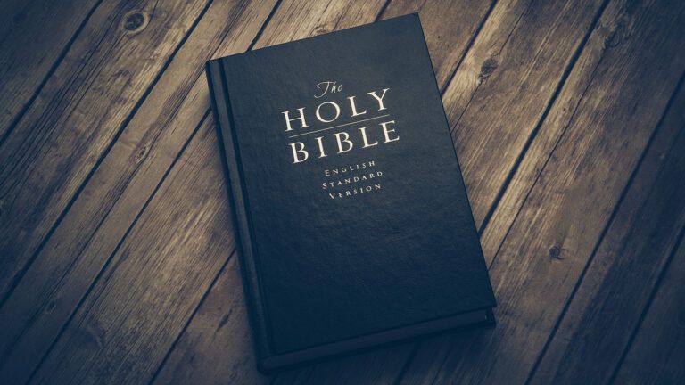 A leather-bound Bible resting on a wooden table