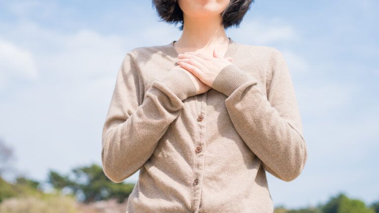 A grateful woman clasps her hands to her heart