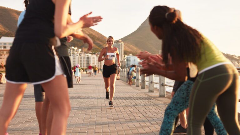 A woman is greeted by encouraging friends as she nears the finish line of a marathon