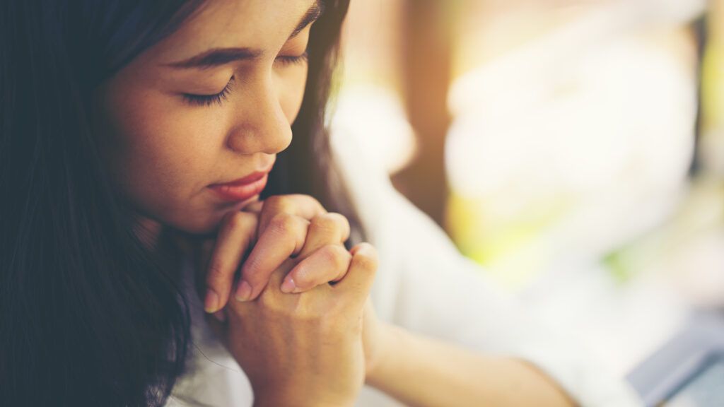 A woman praying; Getty Images