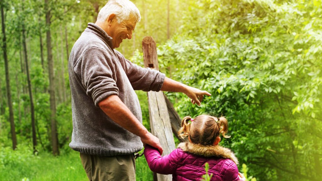 Grandfather showing his granddaughter the woods.