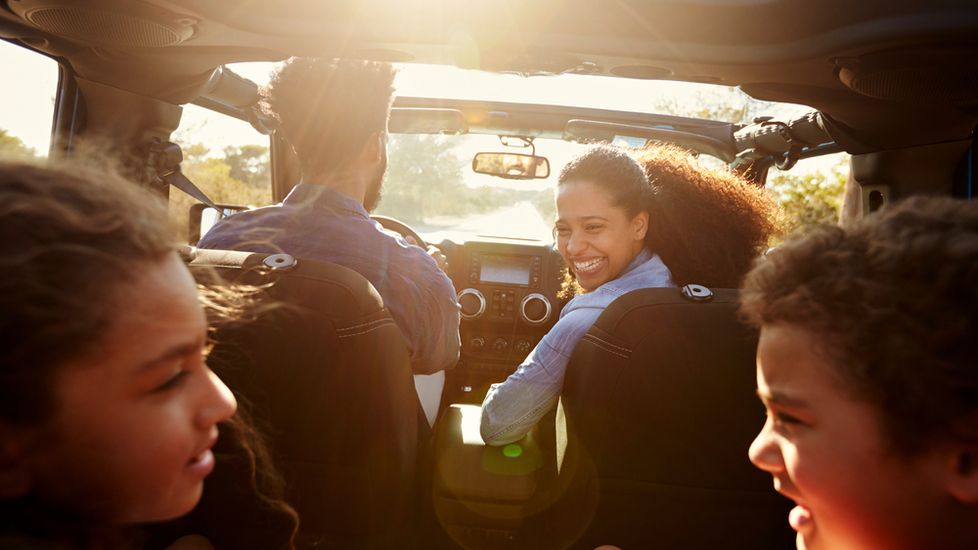 A family in the car on a road trip saying prayers for safe travel