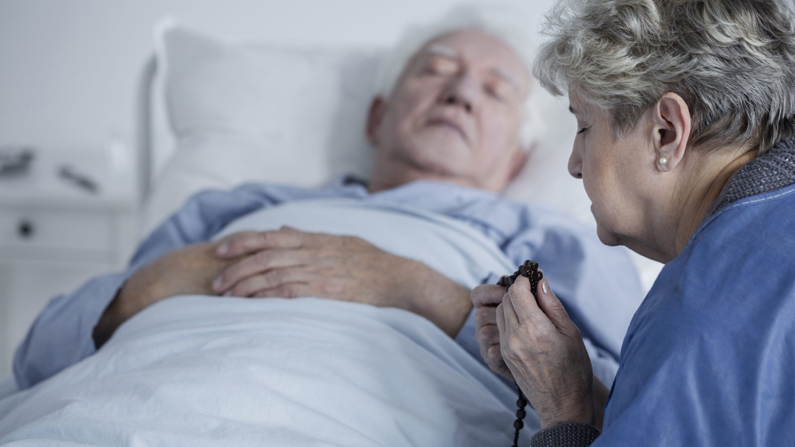 Woman prays for man in hospital bed