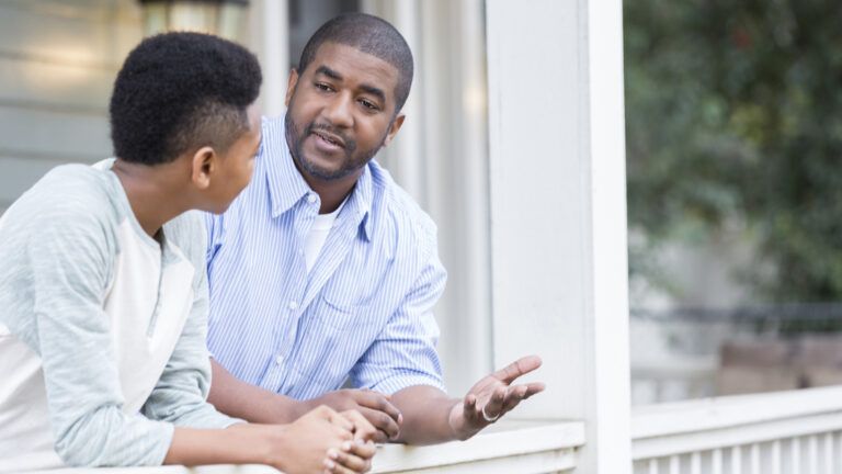 Father and son in serious front porch conversation.