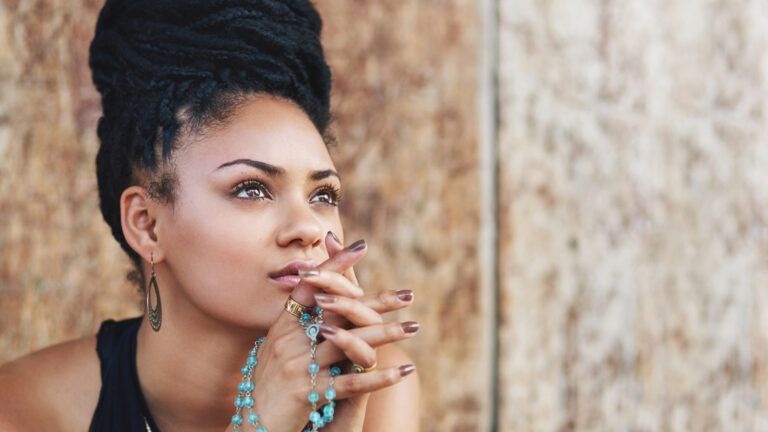 A woman, hands clasped, looks hopefully heavenward