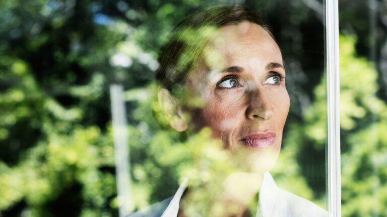 A pensive woman gazes out a window