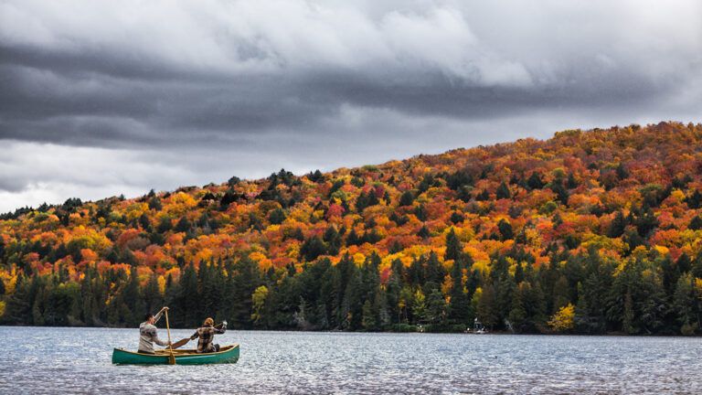 A couple in a canoe on a mountain lake in autumn