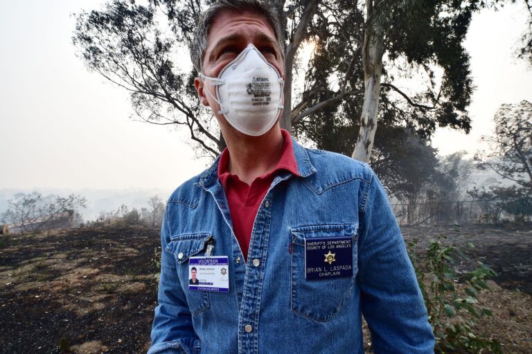 Los Angeles Sheriff's Department chaplain Pastor Brian La Spade walks through properties in the Points Dume neighborhood of Malibu, California, where members of his congregation live, on November 10, 2018, after the Woolsey Fire tore through the neighborhood overnight. - Firefighters in California on Saturday battled raging blazes at both ends of the state that have left at least nine people dead and thousands of homes destroyed, but there was little hope of containing the flames anytime soon. More than 250