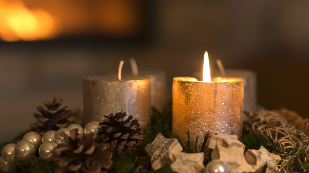 Lit candles on a table being used for Advent reflections