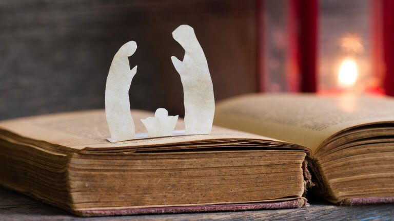 Nativity figures rest on an open Bible