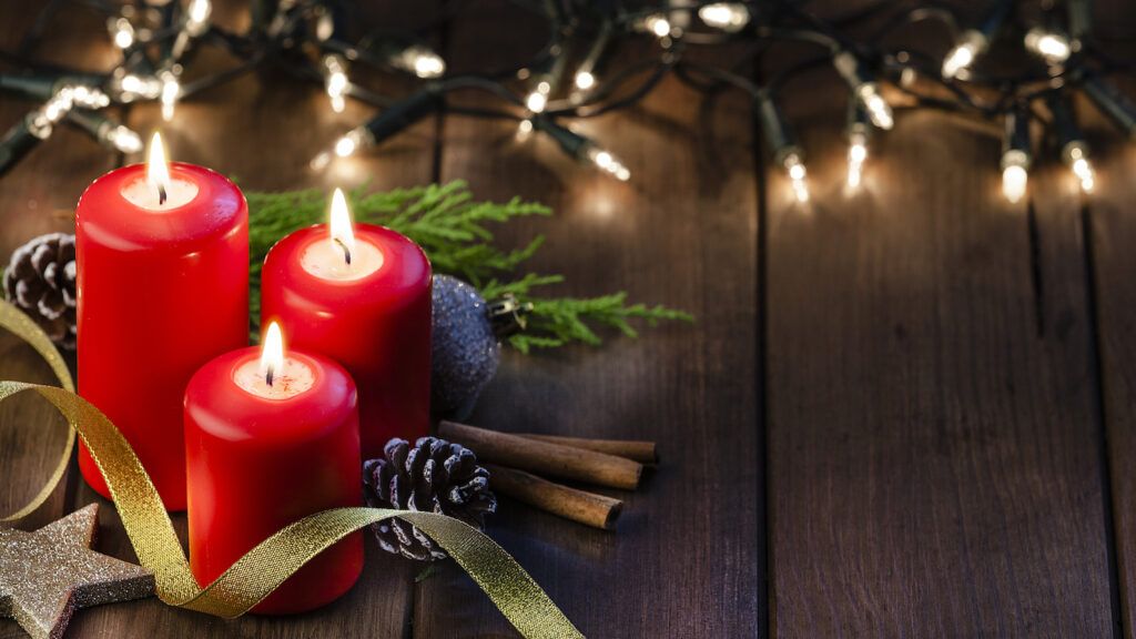 Three red candle lit in prayer for Christmas eve