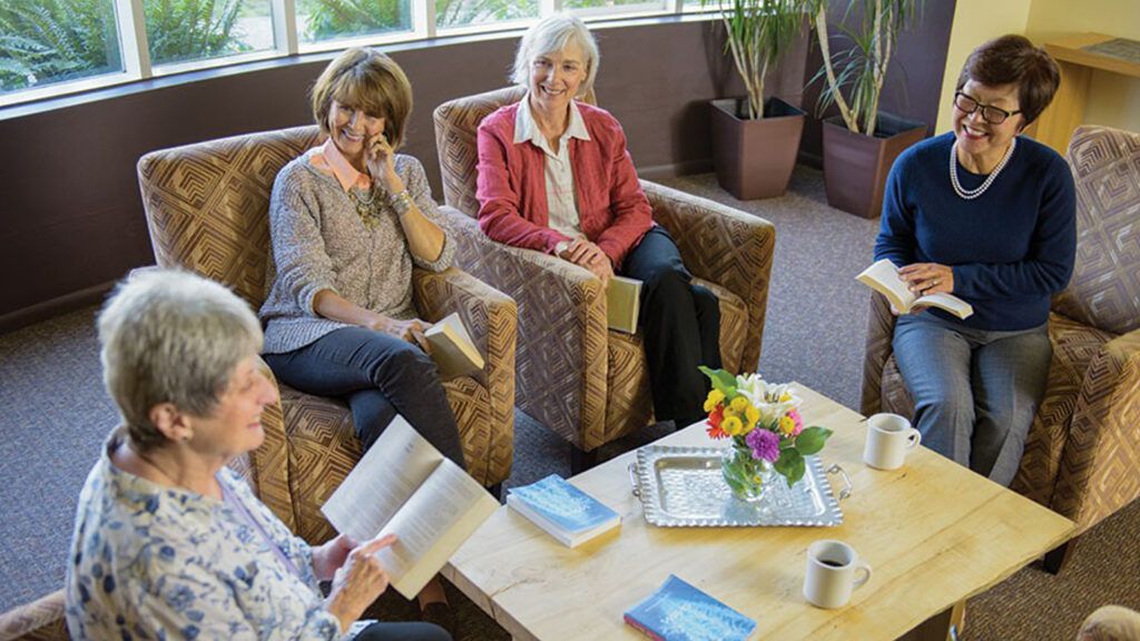 A group of retirees reading together in a circle.