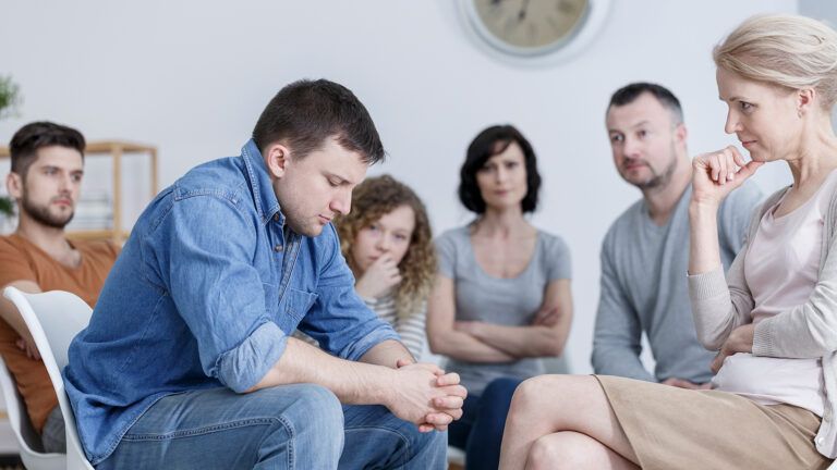 A young man struggles during a recovery support group session