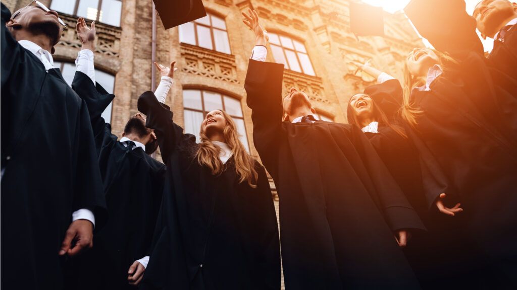 A group of graduates throwing their caps in the air.