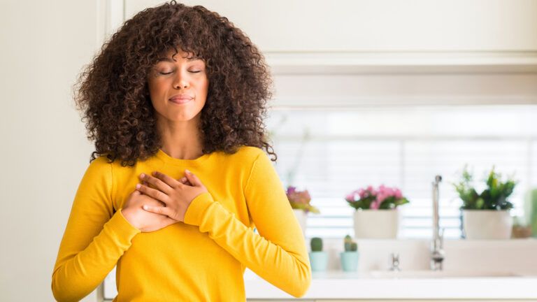 A woman in her home feeling a sense of gratitude.