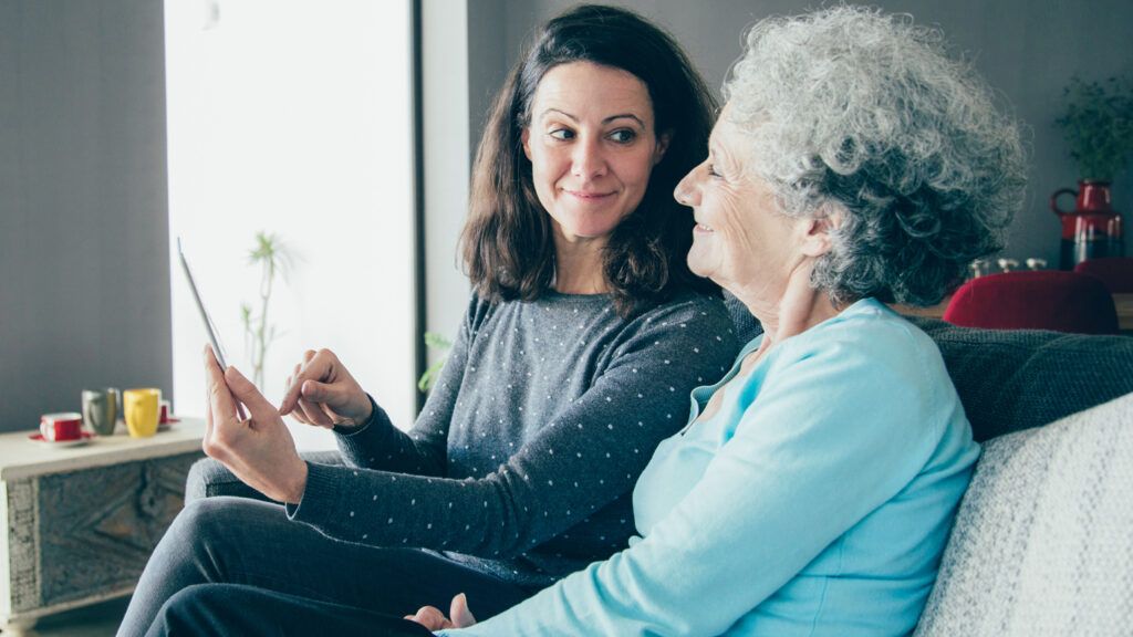 A woman in her golden years spending time with her daughter in their home.