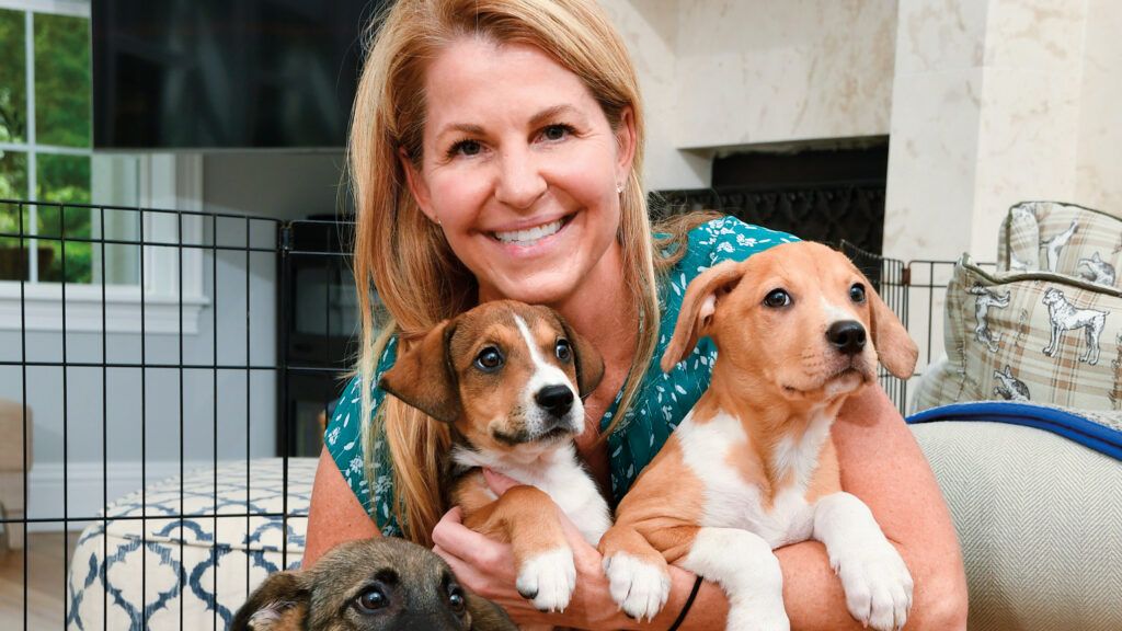 Allison snuggles three of her foster puppies.